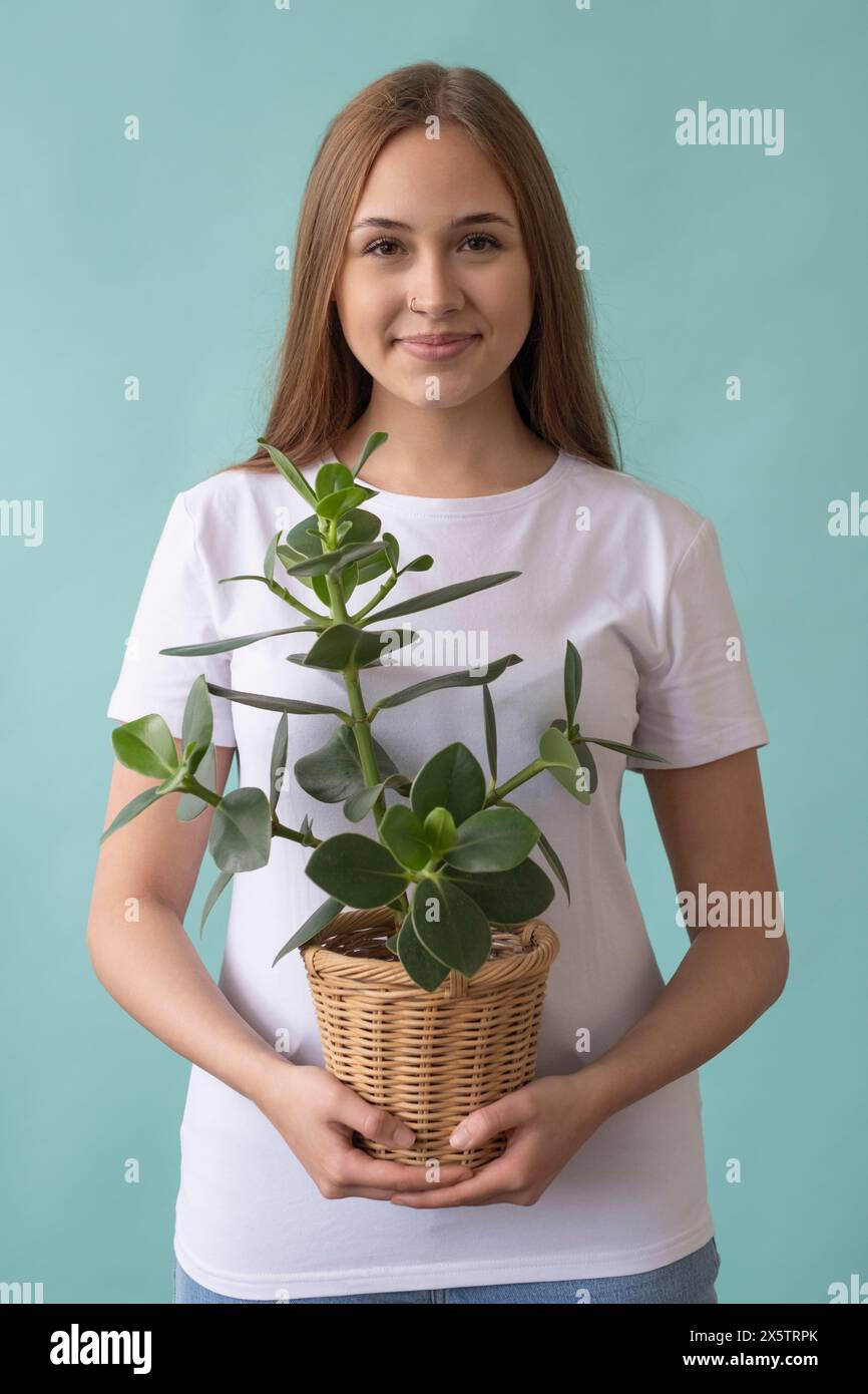 Studio portrait of smiling teenage girl holding potted plant Stock ...