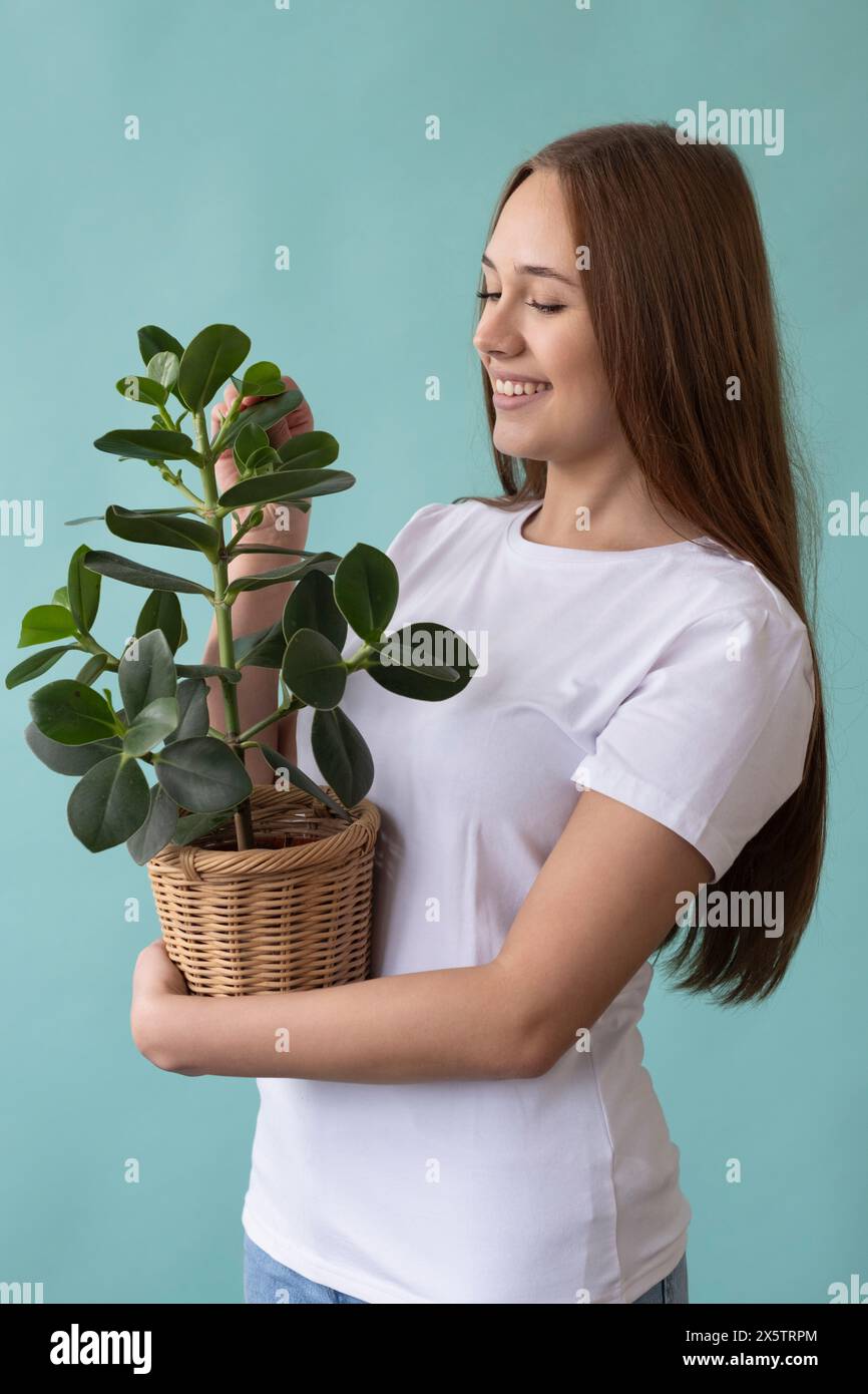 Studio portrait of smiling teenage girl holding potted plant Stock ...