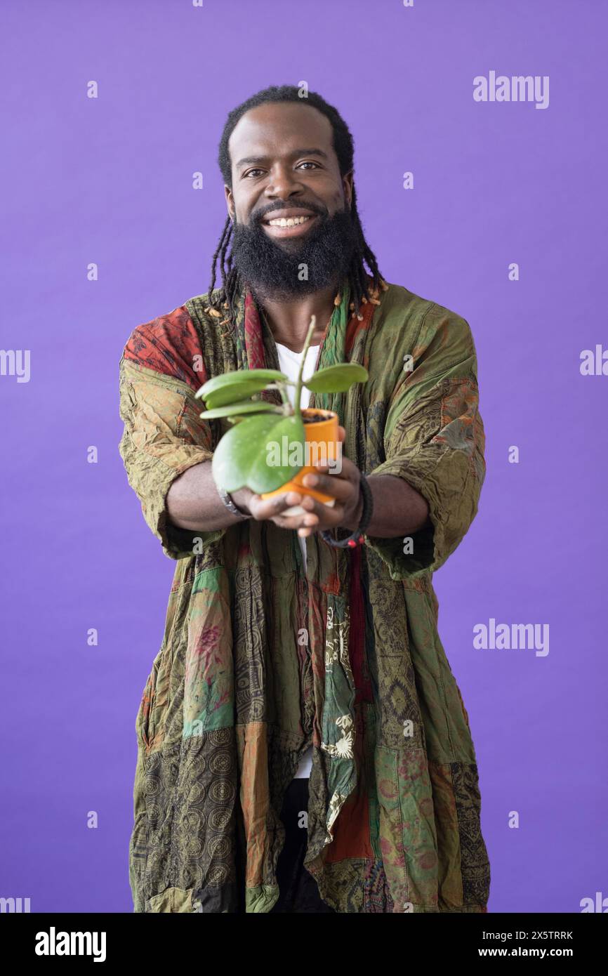 Studio portrait of smiling man holding potted plant Stock Photo - Alamy