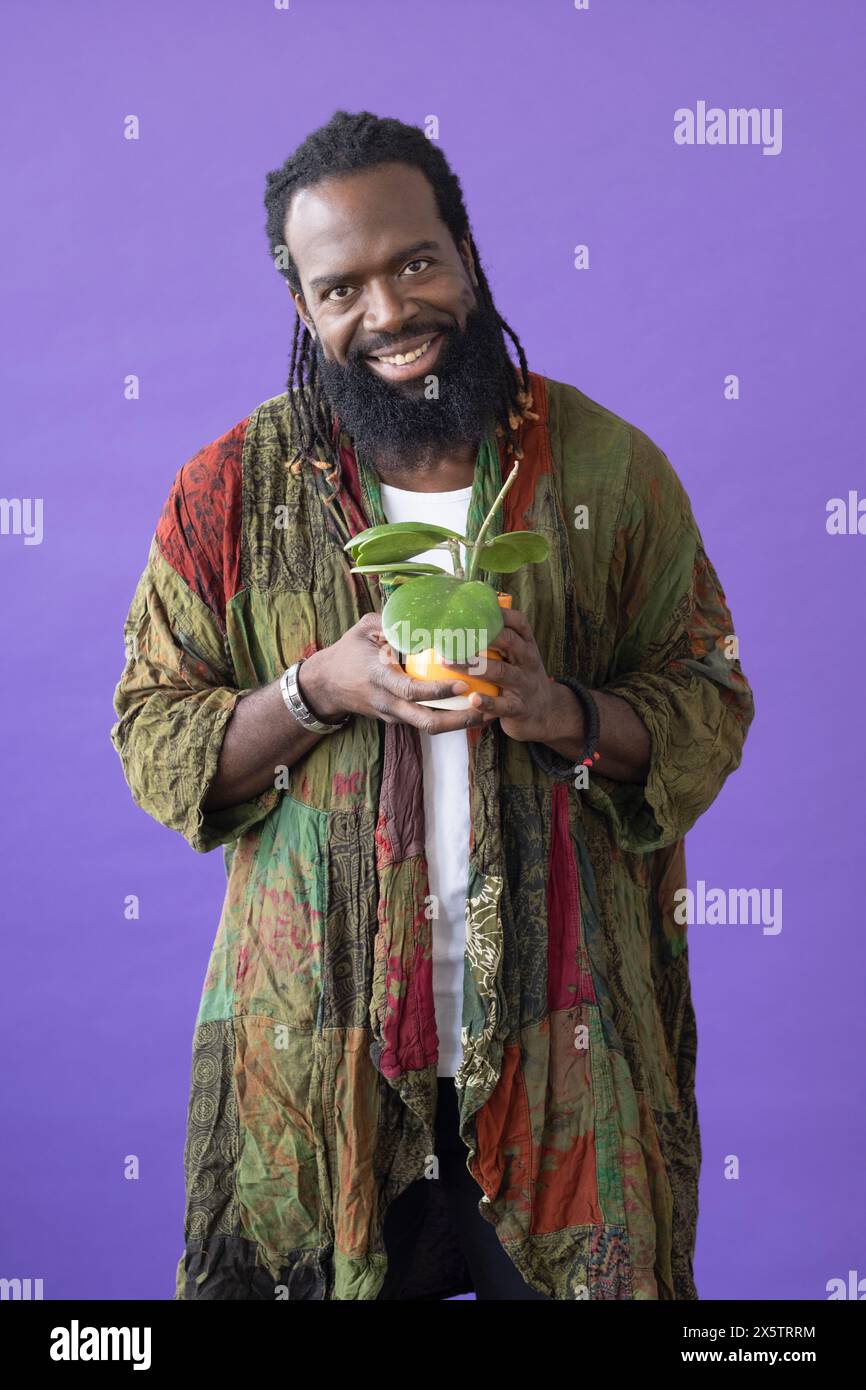 Studio portrait of smiling man holding potted plant Stock Photo - Alamy