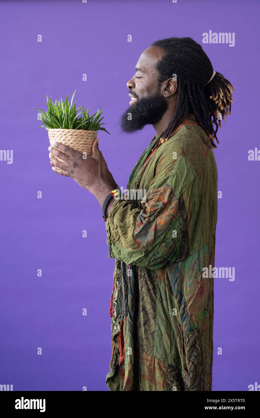Side view of smiling man with eyes closed holding potted plant Stock ...