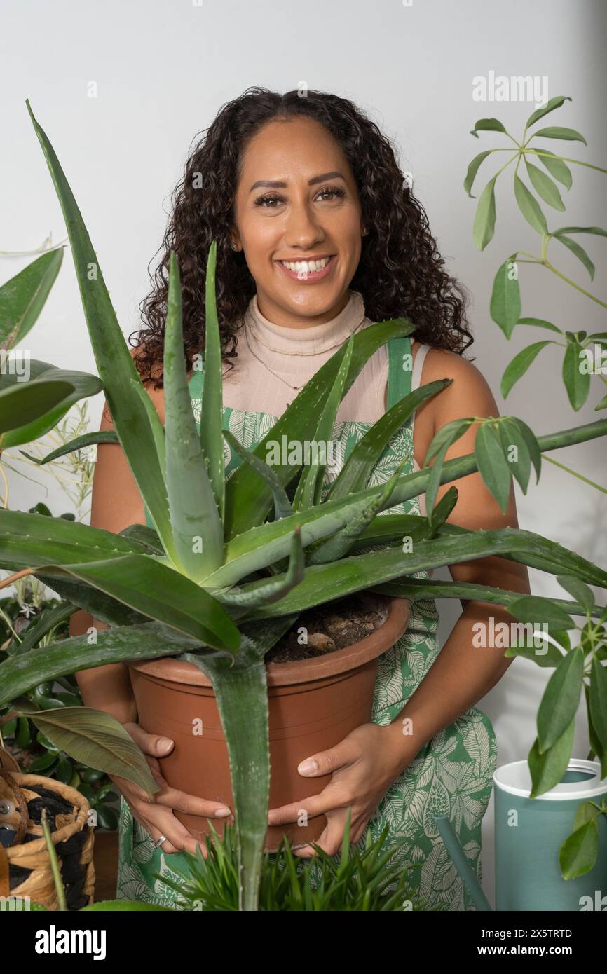 Studio portrait of smiling woman holding potted aloe vera plant Stock ...