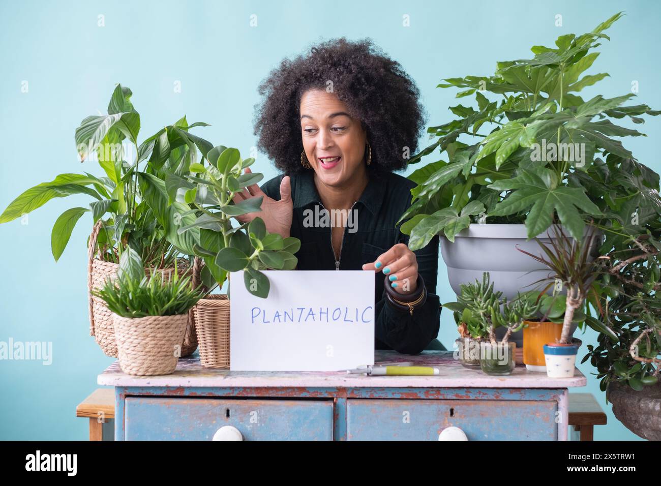 Studio portrait of smiling woman with potted plants and sign Stock ...