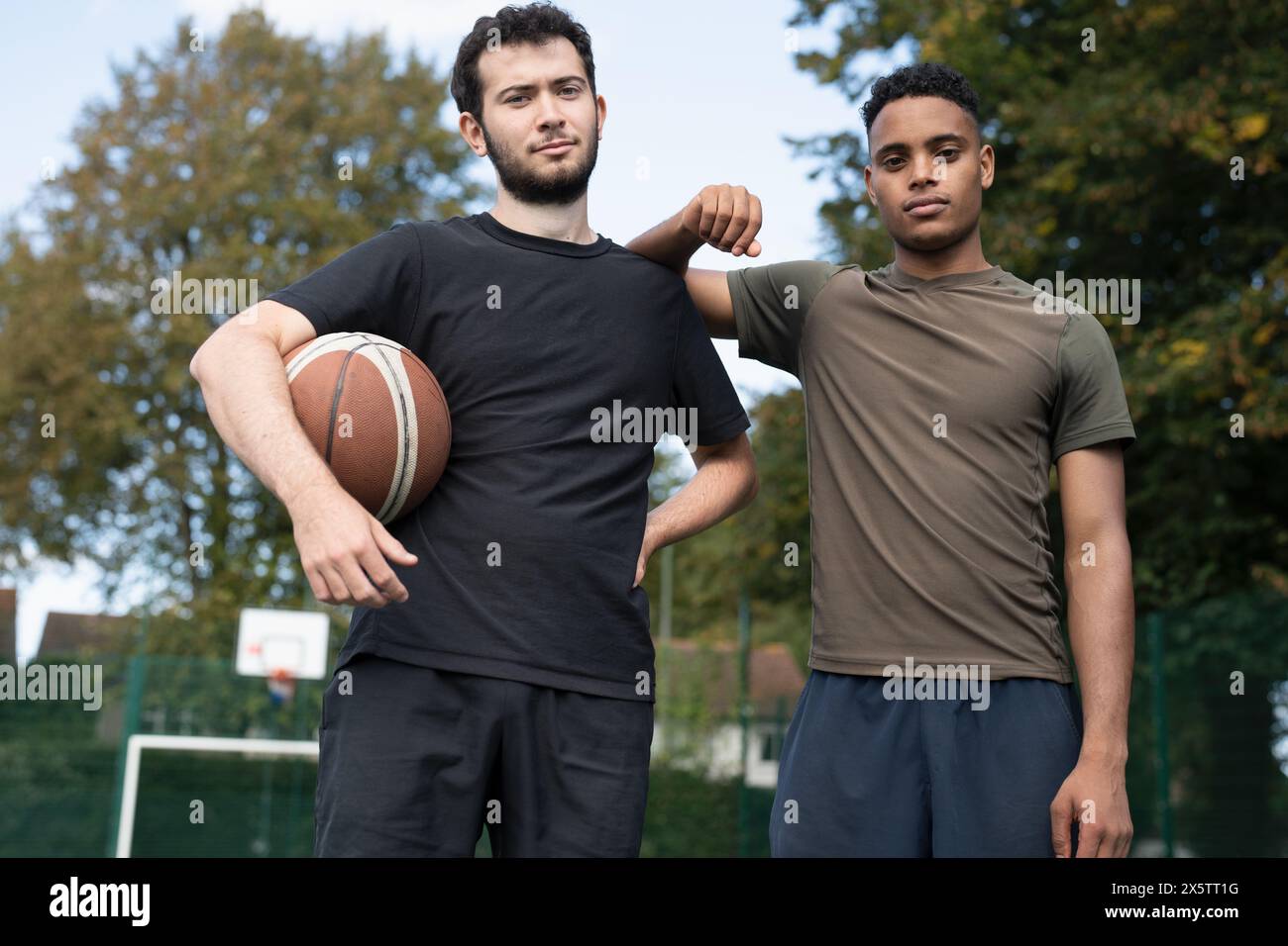 Portrait of two men standing in basketball court Stock Photo - Alamy