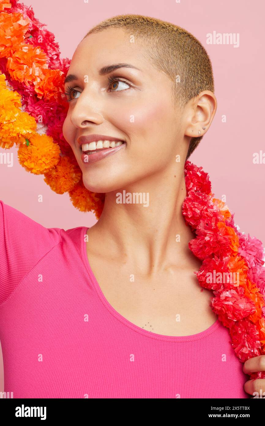 Smiling young blond woman wearing floral garland Stock Photo
