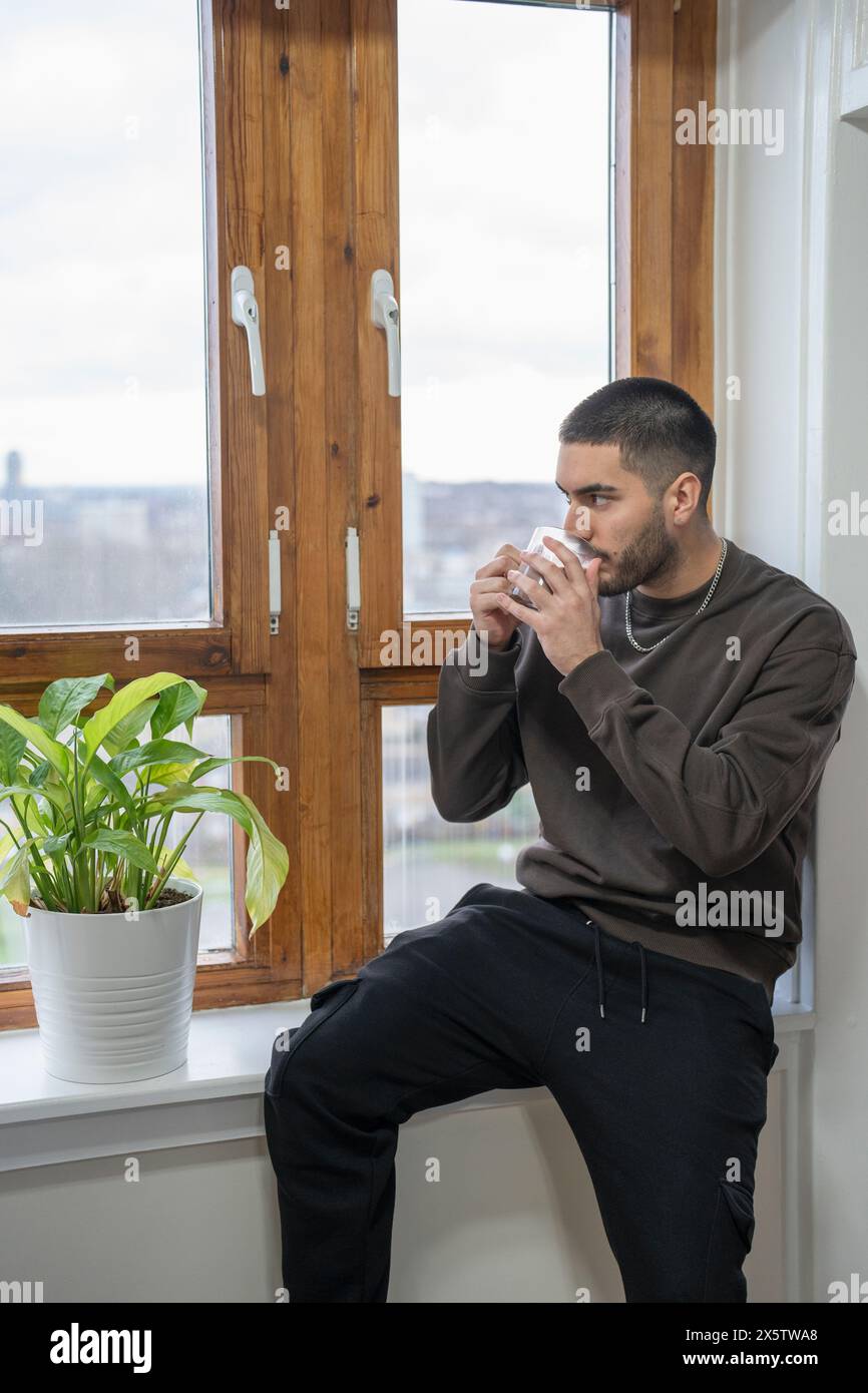 Young man drinking milk tea at home Stock Photo