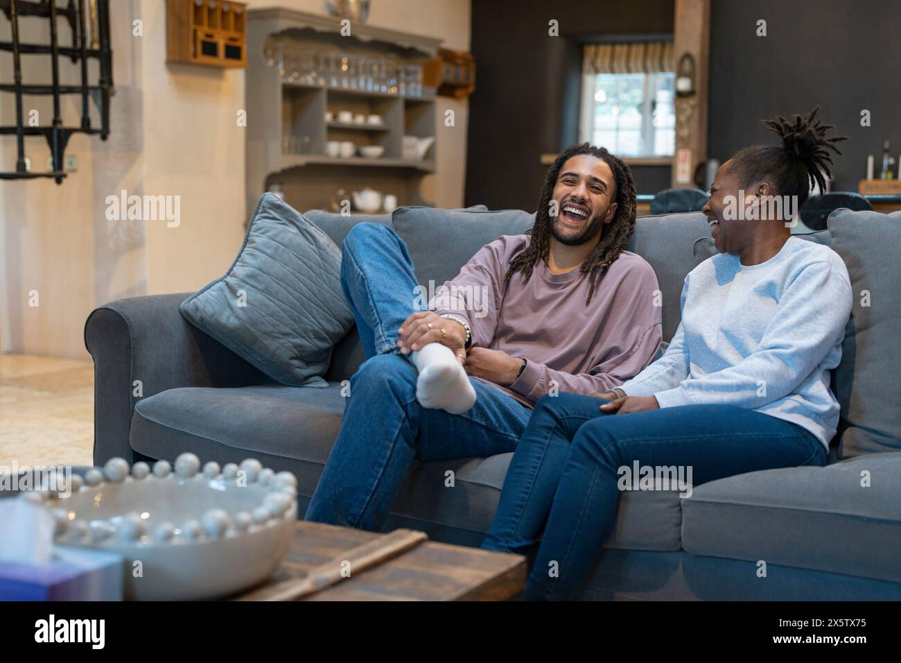 Happy couple sitting on sofa in cozy living room Stock Photo