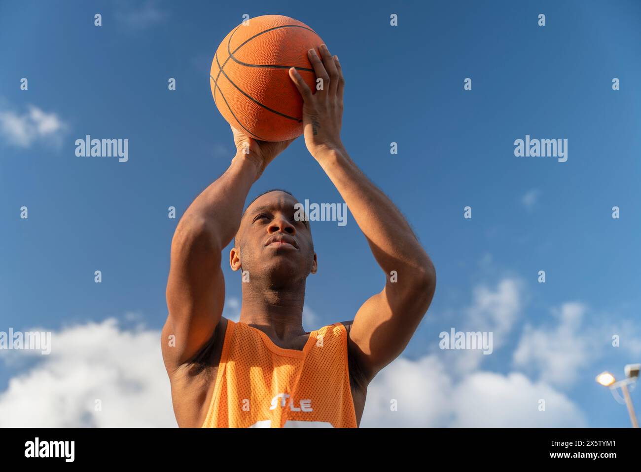 Man holding basketball ball against sky Stock Photo