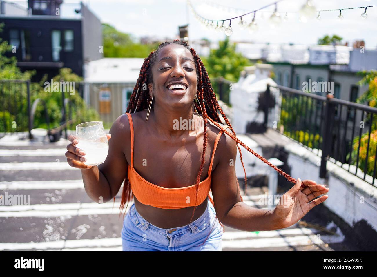 Portrait of smiling woman with drink outdoors Stock Photo