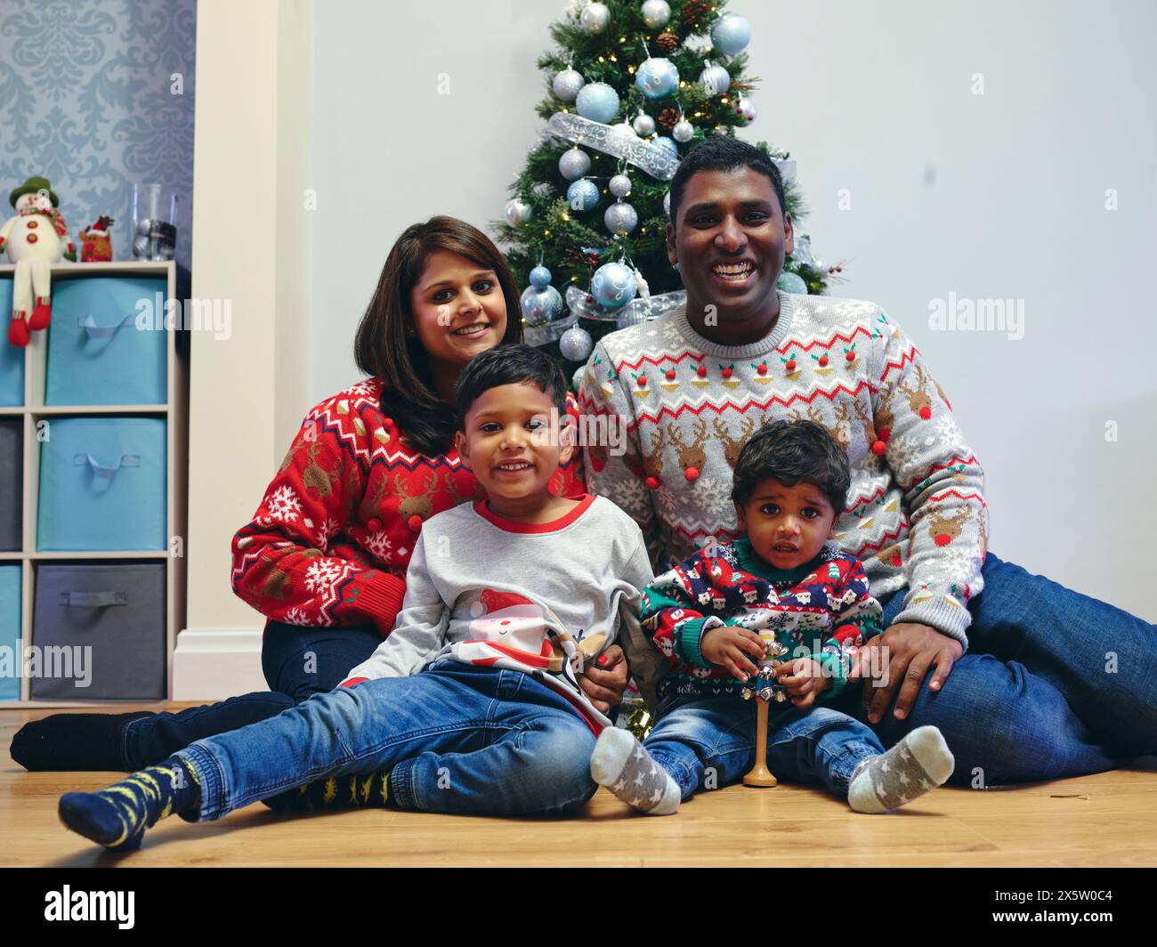 Portrait of family with sons in front of Christmas tree Stock Photo