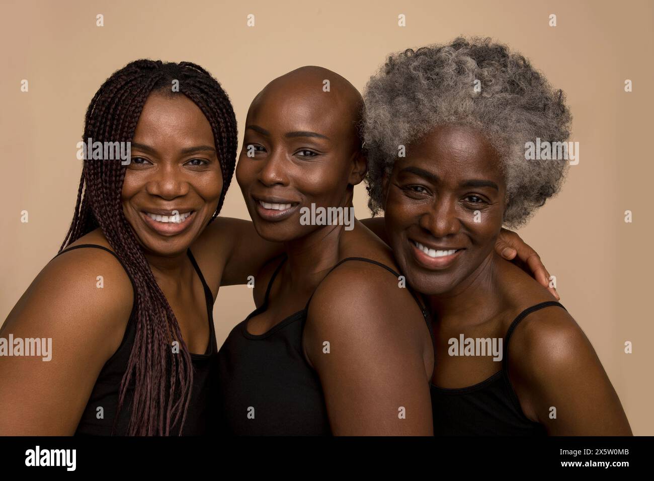 Studio portrait of three smiling women in black tops Stock Photo