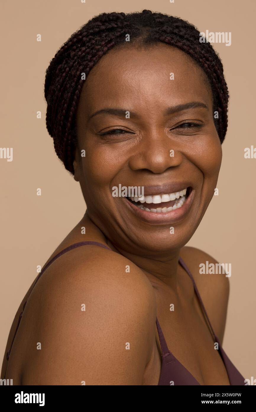 Studio portrait of mature woman with braided hair laughing Stock Photo ...