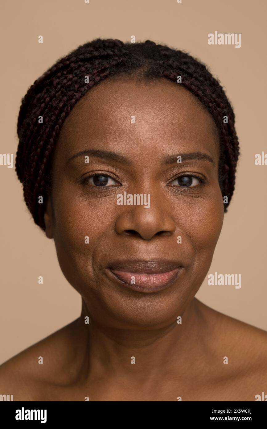 Studio portrait of smiling mature woman with braided hair Stock Photo ...