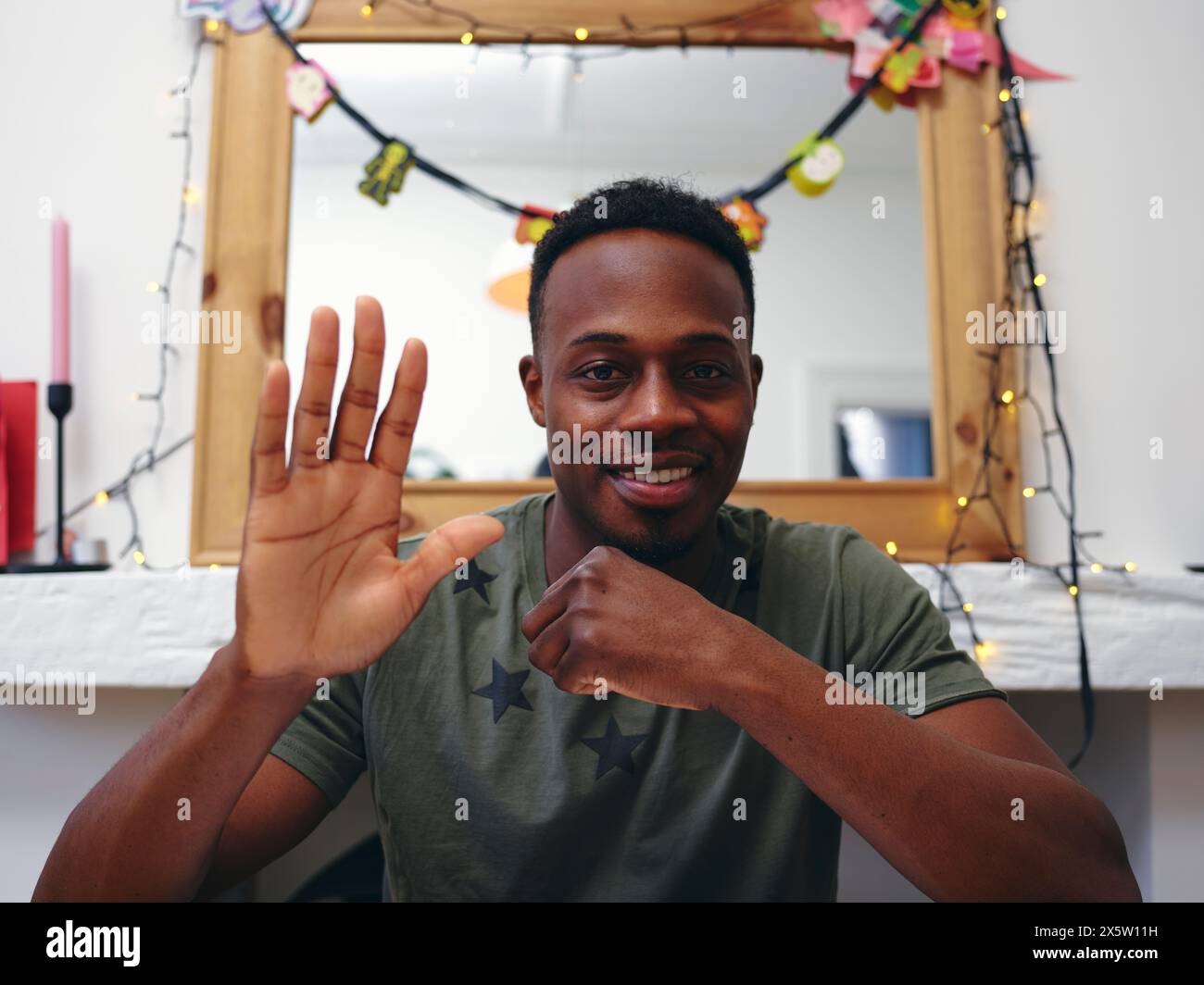 Portrait of man looking at camera and waving hand Stock Photo