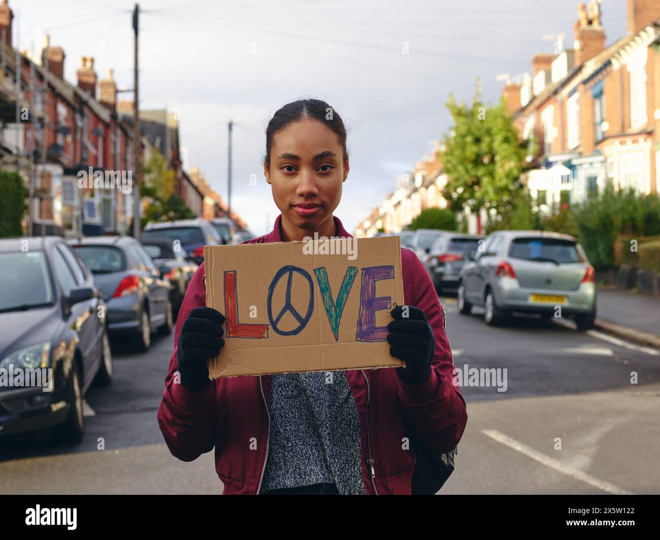 Woman on street holding protest sign with symbol of peace Stock Photo