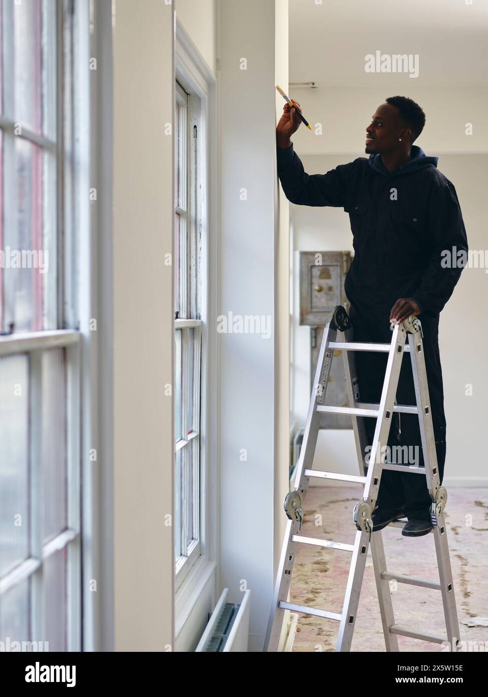 Man standing on ladder and painting house walls Stock Photo - Alamy