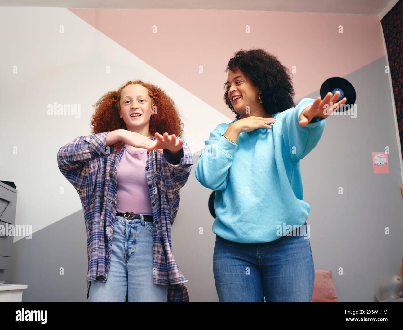 Mother and daughter dancing in room Stock Photo