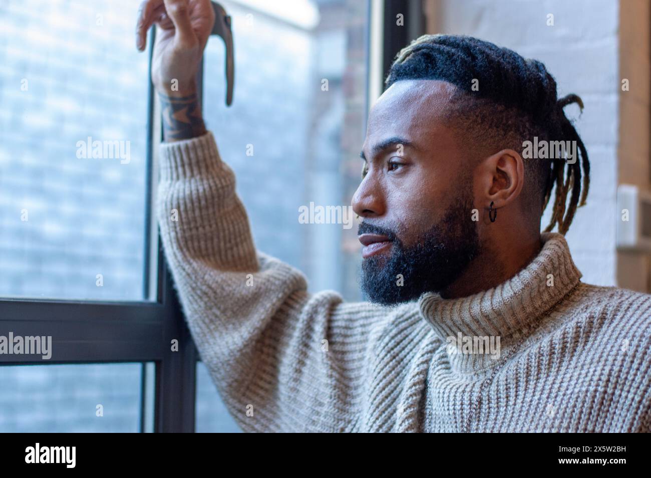 Man looking through window Stock Photo