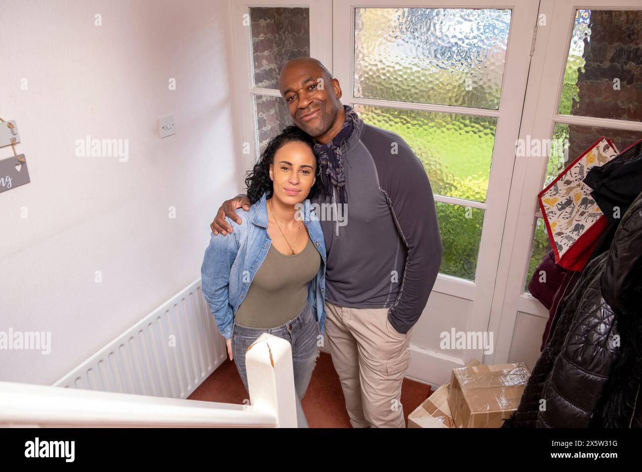 Portrait of smiling couple standing in new house Stock Photo - Alamy