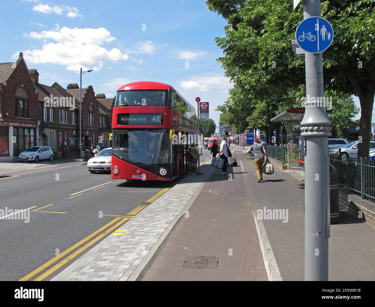 Passengers arriving at a 'floating' bus stop on Lee Bridge Road, Walthamstow, London. People have to cross the cycle path as they get off the bus. Stock Photo