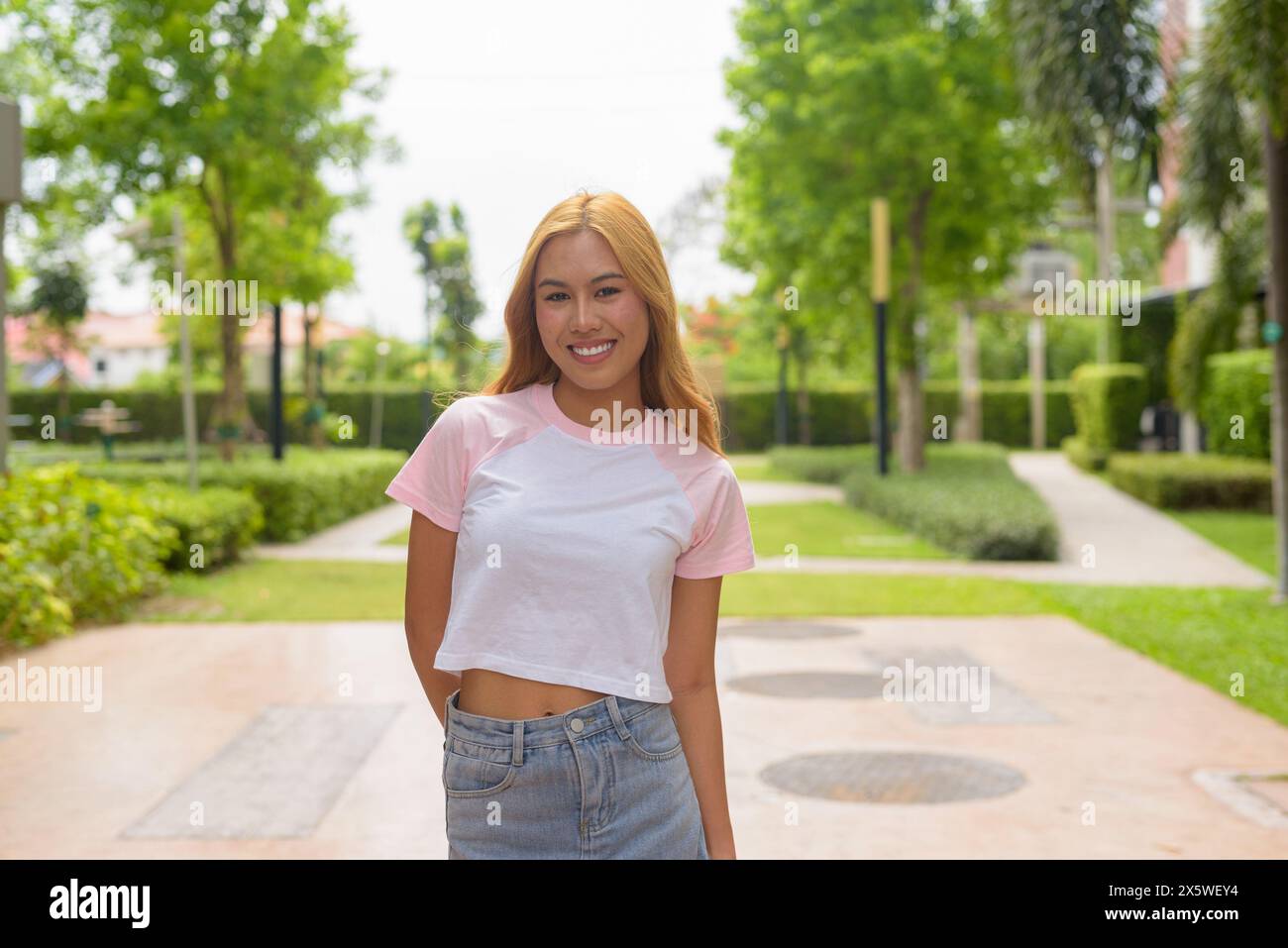 Portrait of beautiful happy Asian girl with blonde hair outdoors Stock Photo