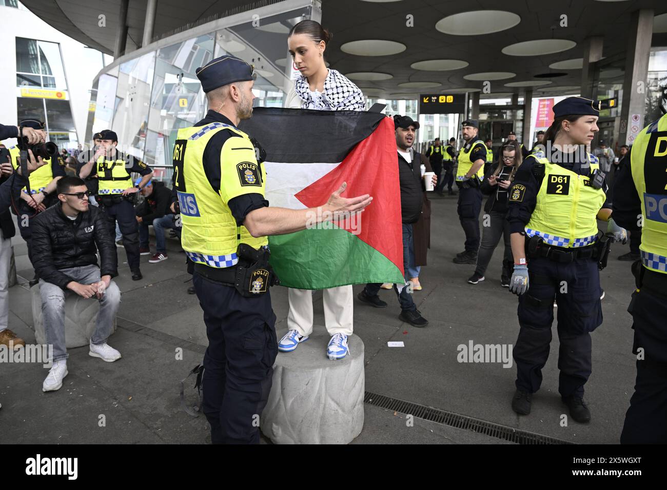 MALMÖ, SWEDEN 20240511A police officer talks to a demonstrator holding palestinian flag during a demonstration in support of Palestine and against Israel's participation in the 68th edition of the Eurovision Song Contest (ESC) at Dagvattenparken outside Malmö Arena, in Malmö, Sweden, on Saturday, May 11, 2024. Photo: Jessica Gow/TT/Code 10070 Credit: TT News Agency/Alamy Live News Stock Photo