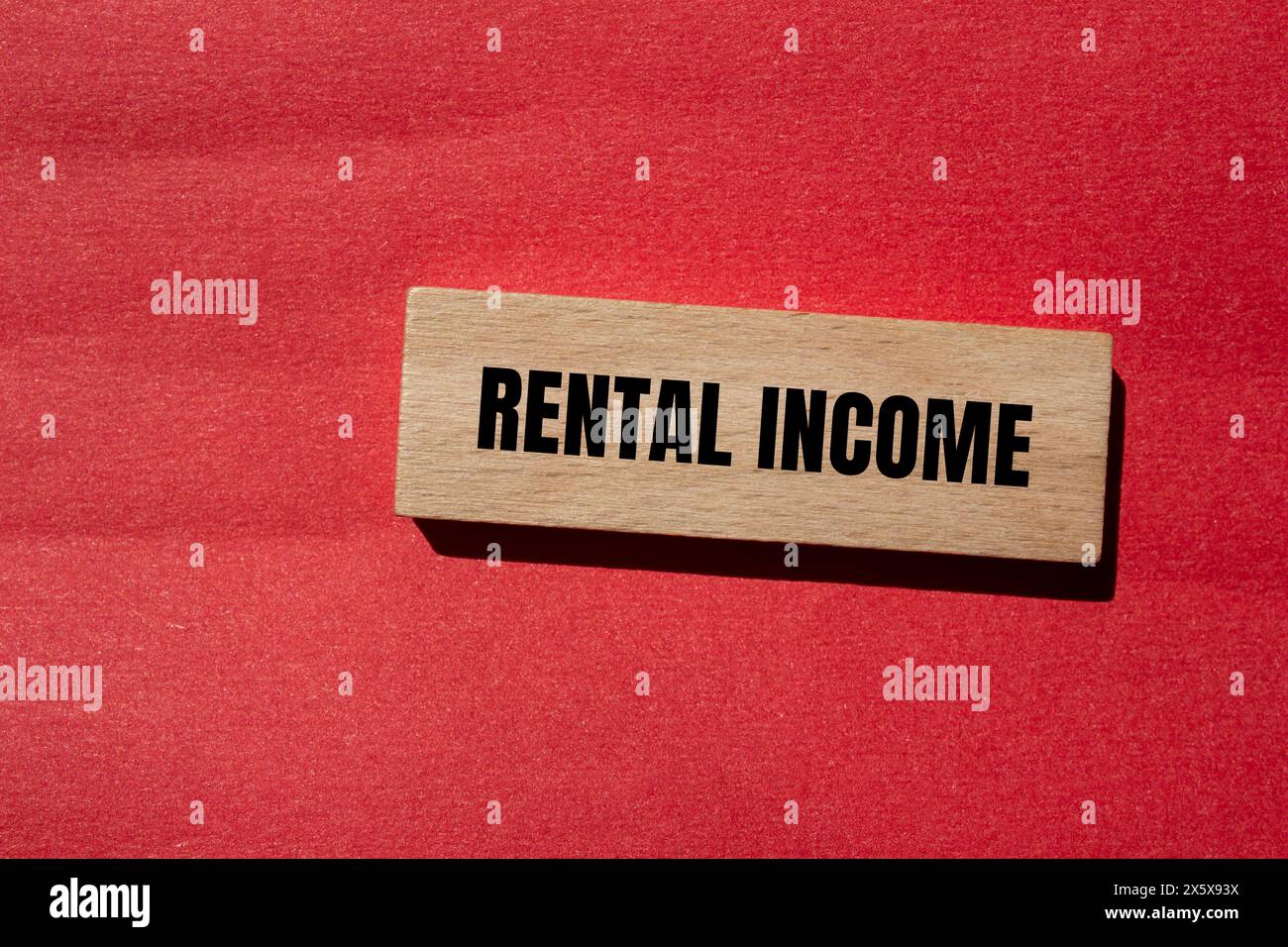 Rental income words written on wooden block with red background ...