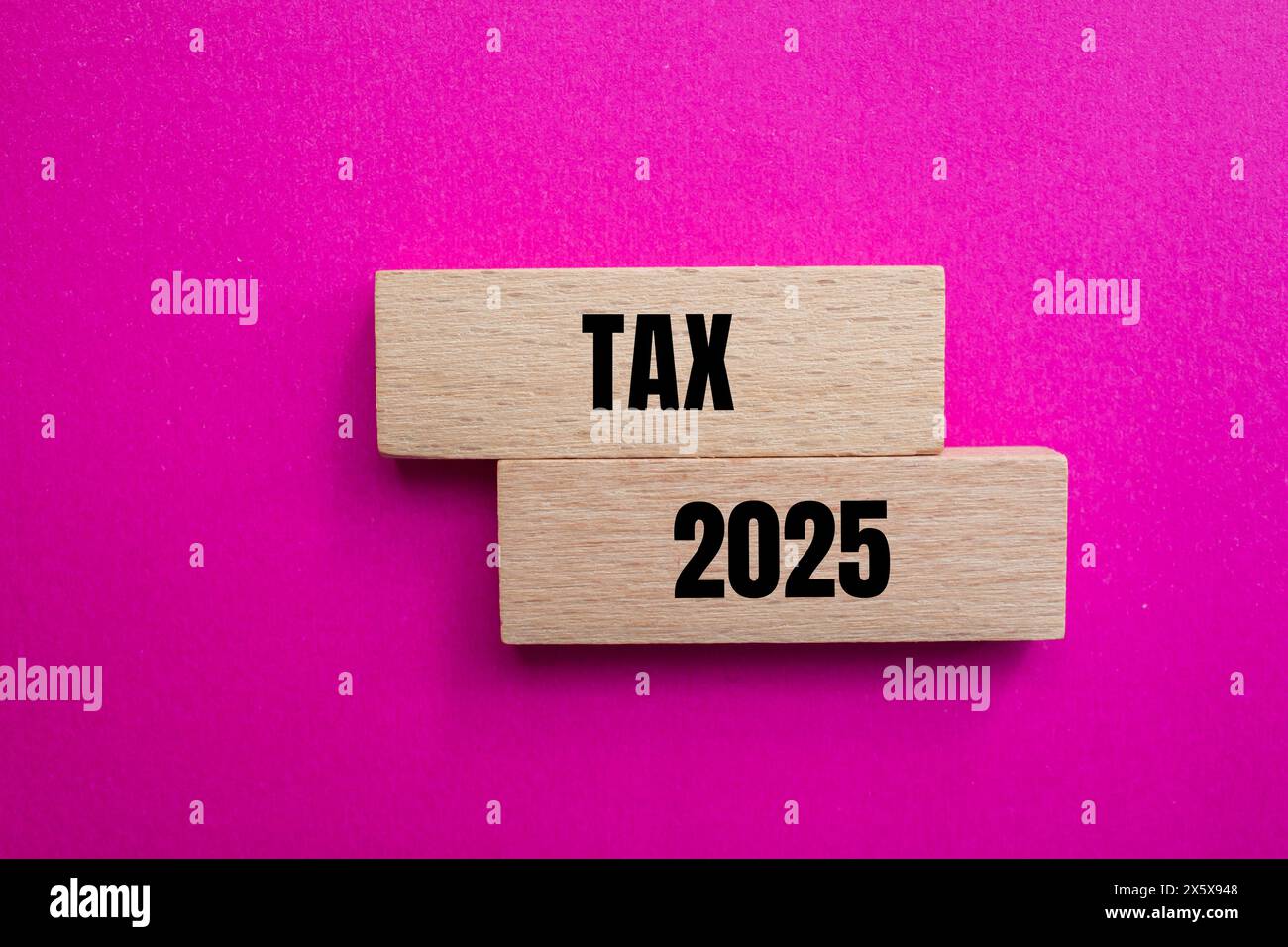 Tax 2025 words written on wooden blocks with pink background. Conceptual business tax 2025