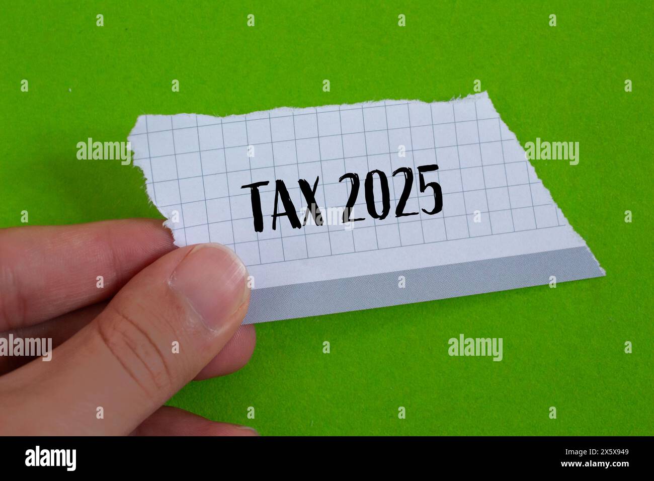 Tax 2025 words written on ripped paper with green background. Conceptual business tax 2025