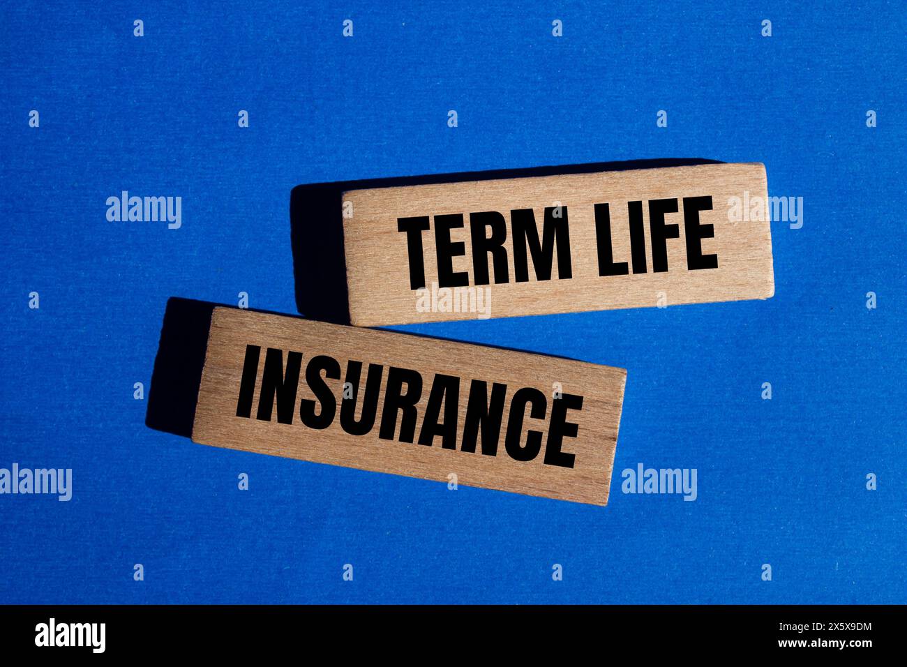 Term life insurance words written on wooden blocks with blue background. Conceptual term life insurance symbol. Copy space. Stock Photo