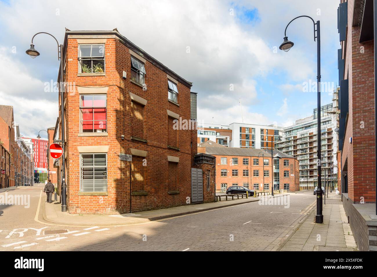 Old brick buildings converted into apartments and new apartment buildings along cobbled streets in a city redevelopment Stock Photo