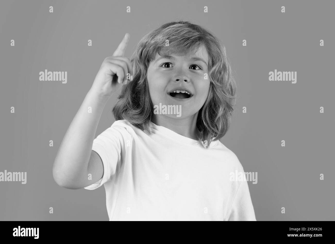 Funny kid boy have idea on studio isolated background. Surprised face, amazed emotions of child. Portrait of school boy with finger pointed up. Stock Photo
