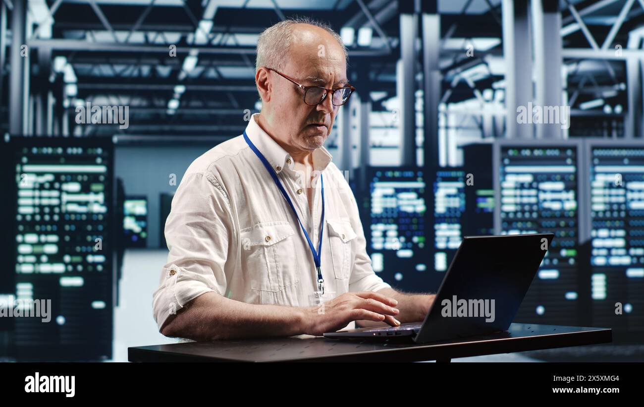 Certified technician expertly managing data while navigating in industrial server room. Professional ensuring optimal cybersecurity protection, optimizing systems and performing necessary updates Stock Photo