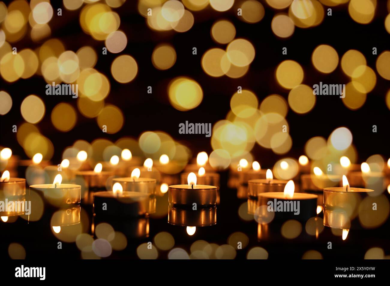 Burning candles on mirror surface in darkness, bokeh effect Stock Photo ...