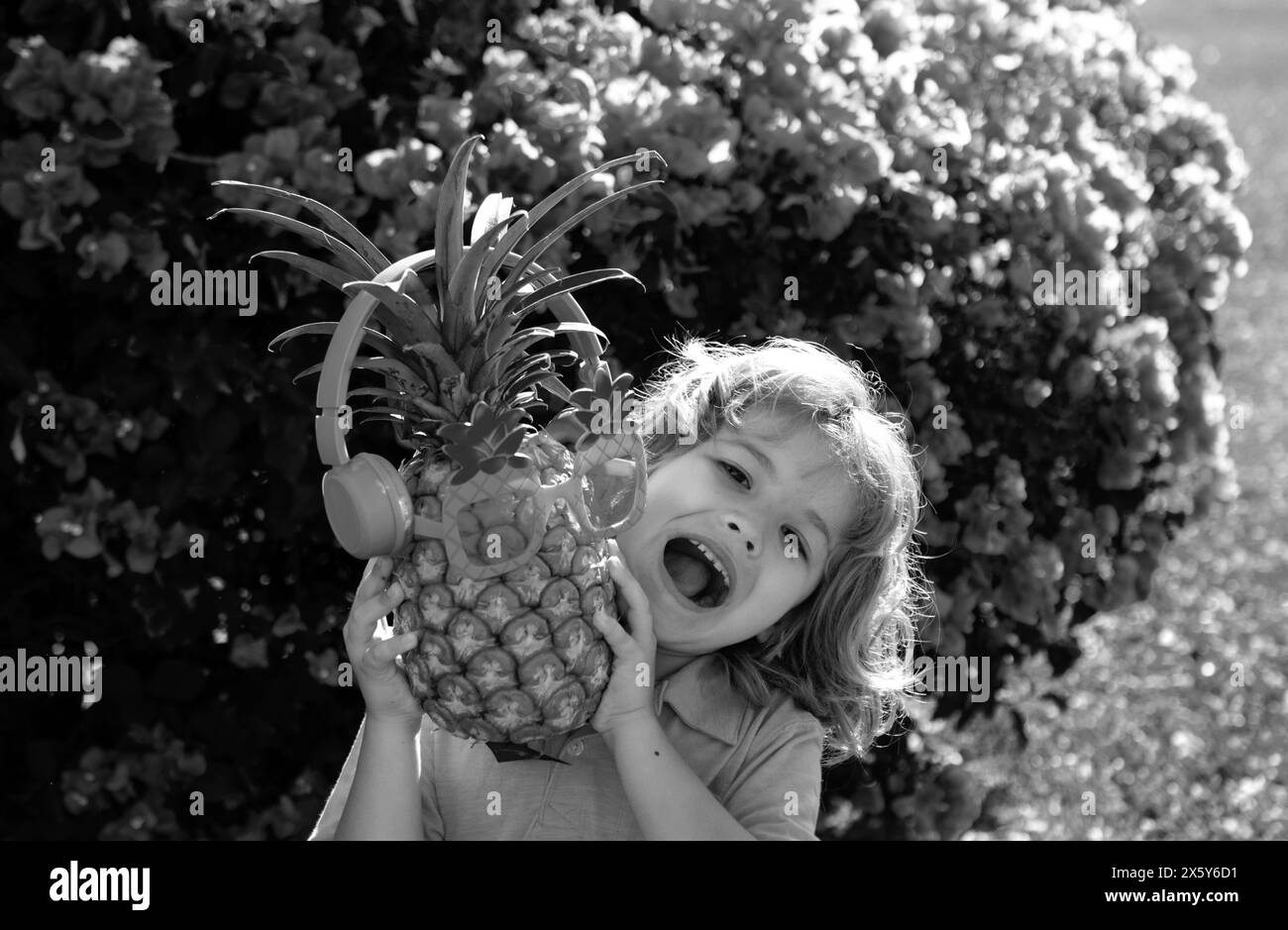 Child boy holding pineapple smiling with happy face. Summer fruits Stock Photo