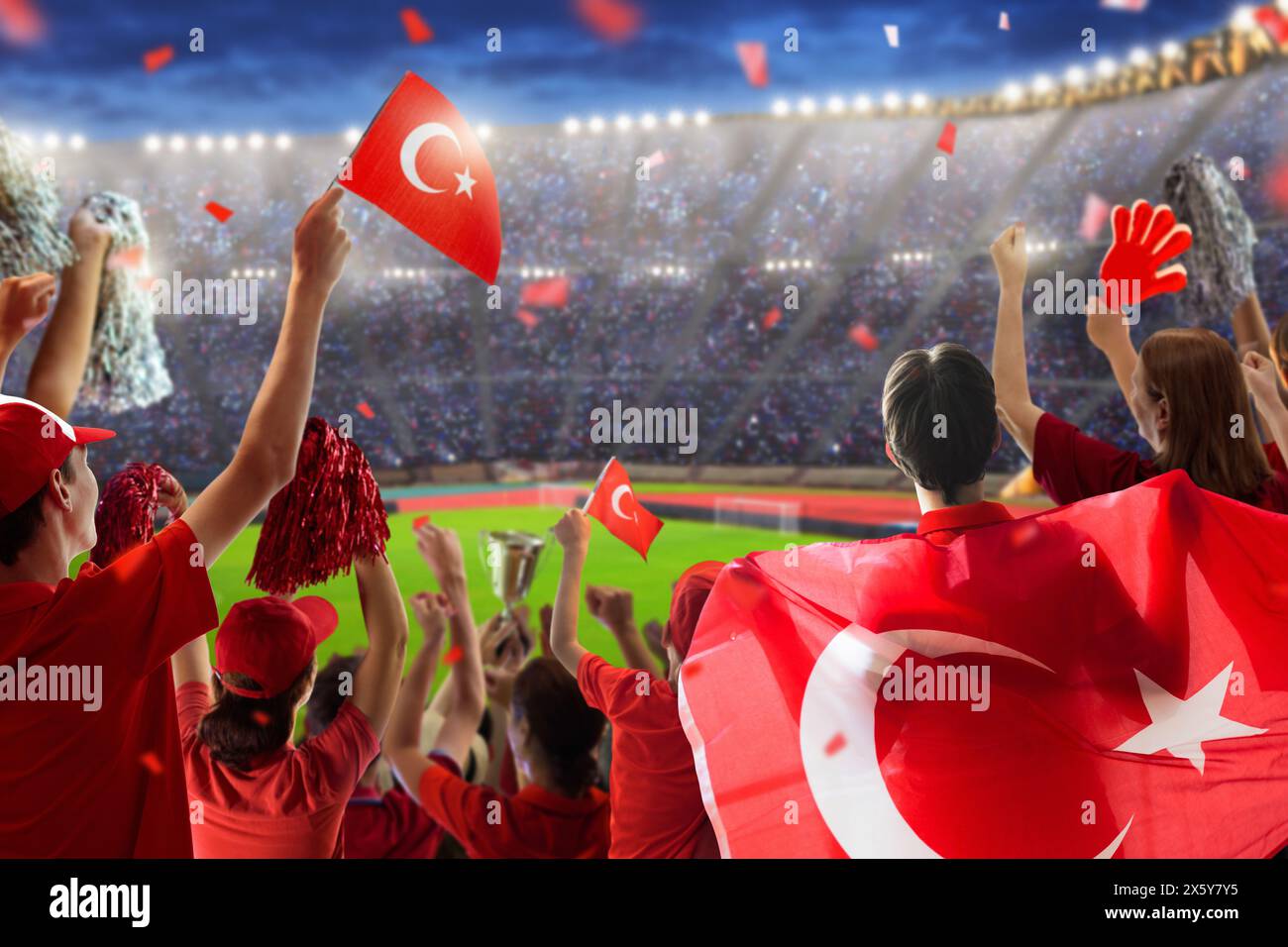 Turkey football supporter on stadium. Turkish fans on soccer pitch watching team play. Group of supporters with Turkiye flag and national jersey cheer Stock Photo