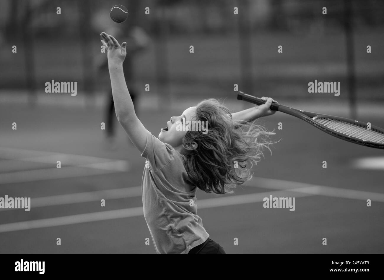 Child boy playing tennis on court. Little kid hit tennis ball with ...