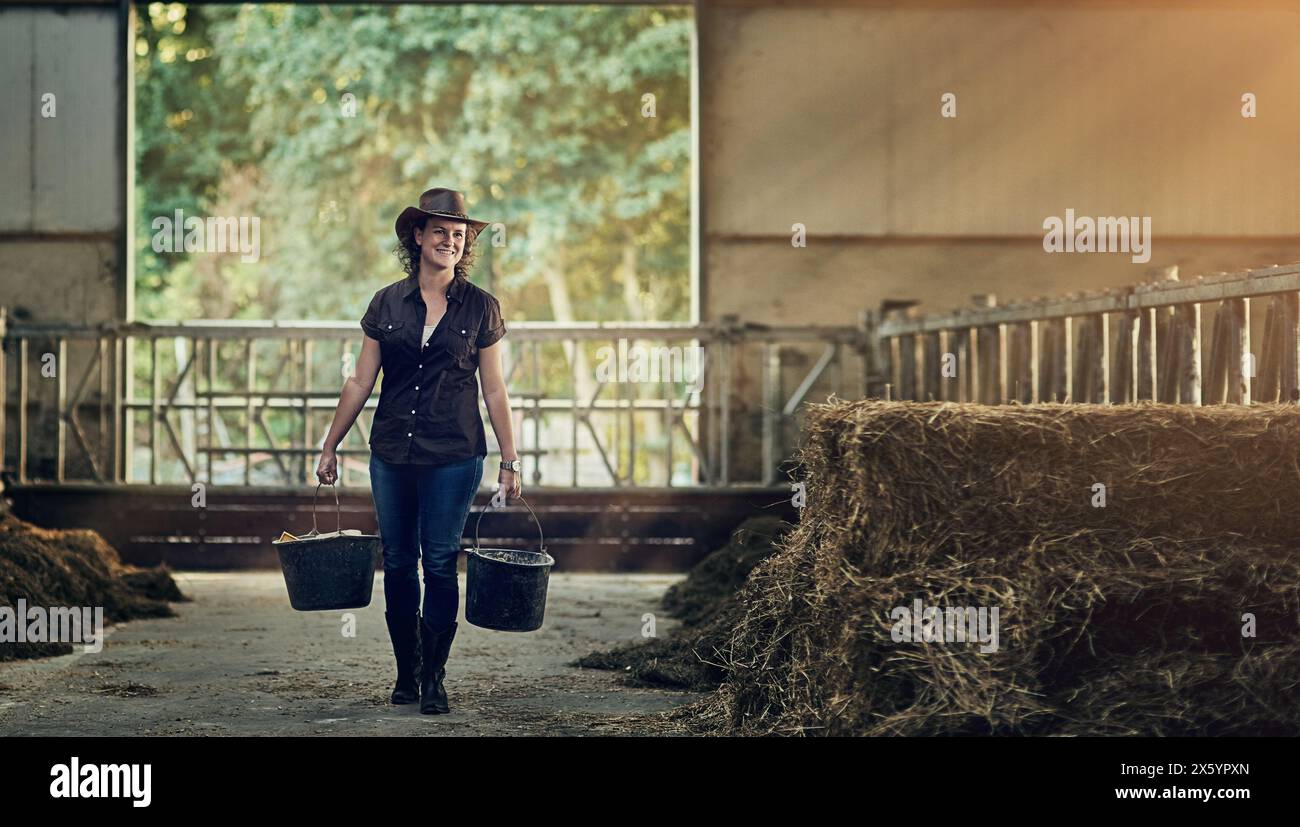 Farm, woman and work with bucket in barn for agriculture ...