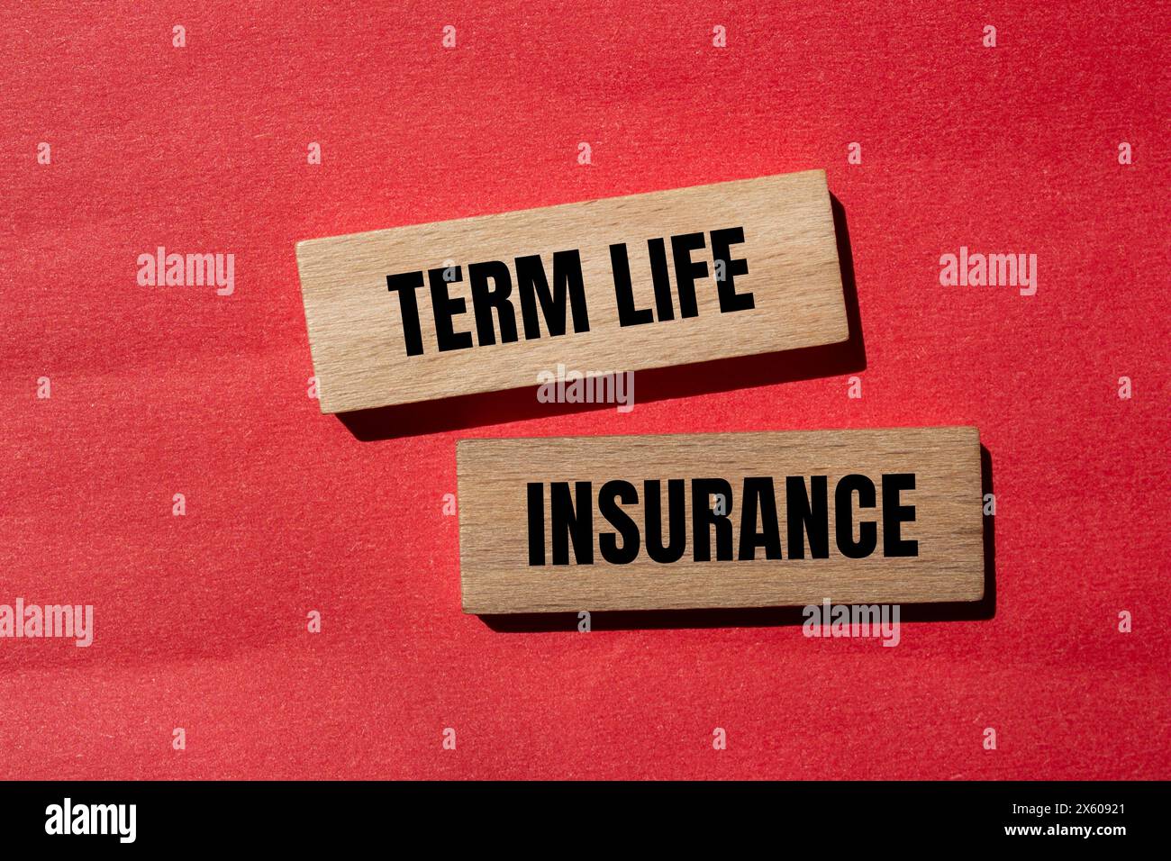 Term life insurance words written on wooden blocks with red background. Conceptual term life insurance symbol. Copy space. Stock Photo