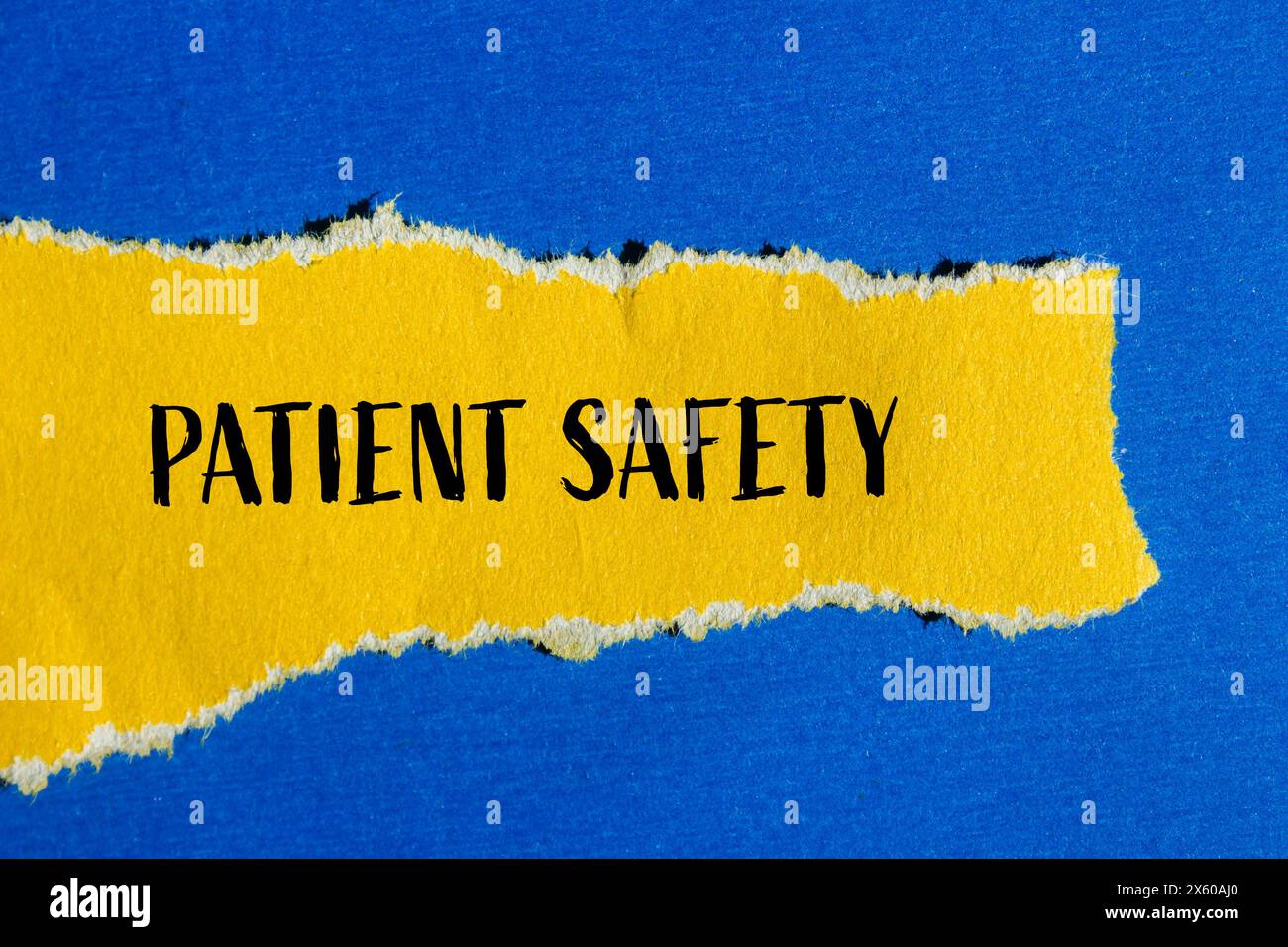 Patient safety words written on ripped yellow paper with blue background. Conceptual patient safety symbol. Copy space. Stock Photo