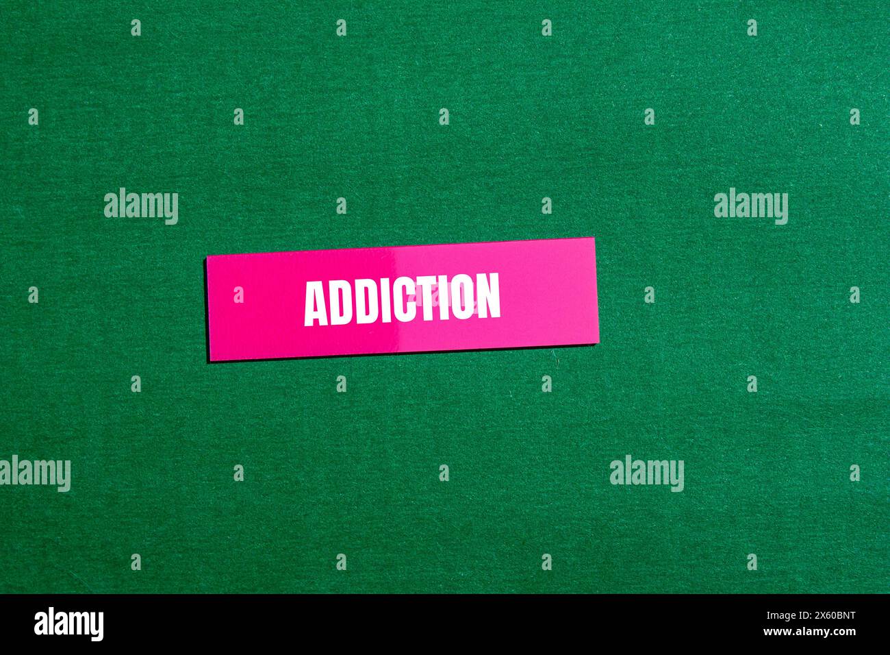 Addiction word written on pink paper sticker with green background. Conceptual addiction word symbol. Copy space. Stock Photo