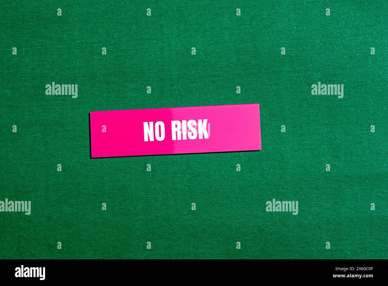 No risk words written on pink paper sticker with green background. Conceptual no risk symbol. Copy space. Stock Photo