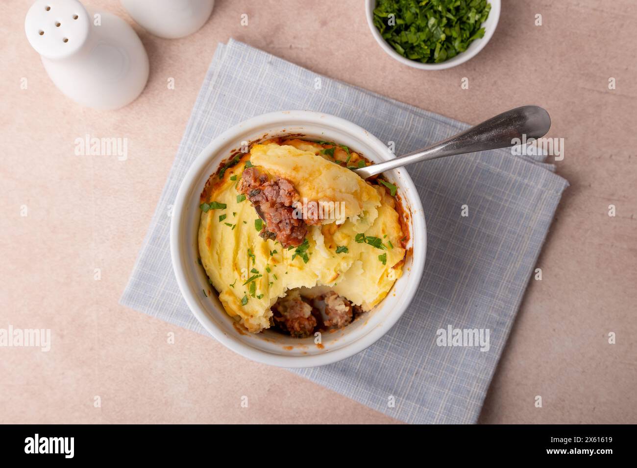 Shepherd's pie in a portioned white baking dish. Homemade traditional casserole (gratin) with minced meat and mashed potatoes. Selective focus, close- Stock Photo
