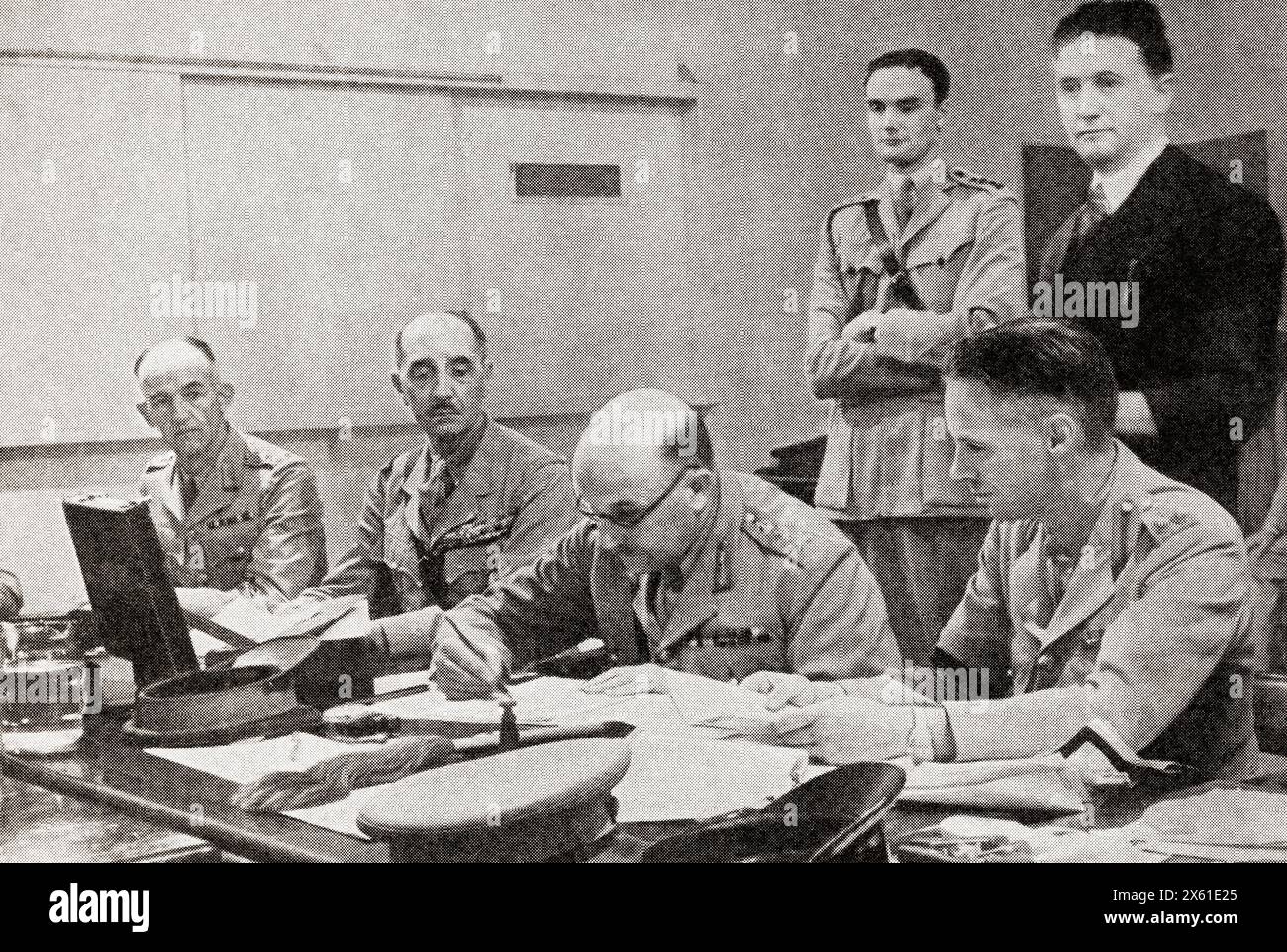 Syria under allied control.  Sir Henry Maitland Wilson with Catroux on his right, signing the ceasefire in Syria on behalf of Great Britain, 12 July, 1941.  Field Marshal Henry Maitland Wilson, 1st Baron Wilson, 1881 – 1964, aka Jumbo Wilson.  Senior British Army officer.  Georges Albert Julien Catroux, 1877 – 1969.  French Army general and diplomat.  From The War in Pictures, Sixth Year. Stock Photo
