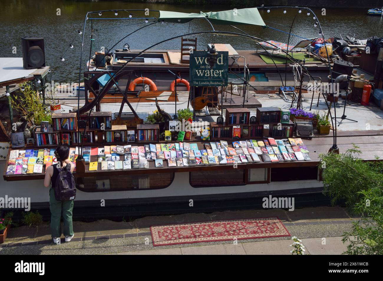 London, UK. 12th May 2024. A customer browses the selection at the Word On The Water barge bookshop on Regent's Canal in King's Cross, as the UK records the hottest day of the year so far. Credit: Vuk Valcic/Alamy Live News Stock Photo
