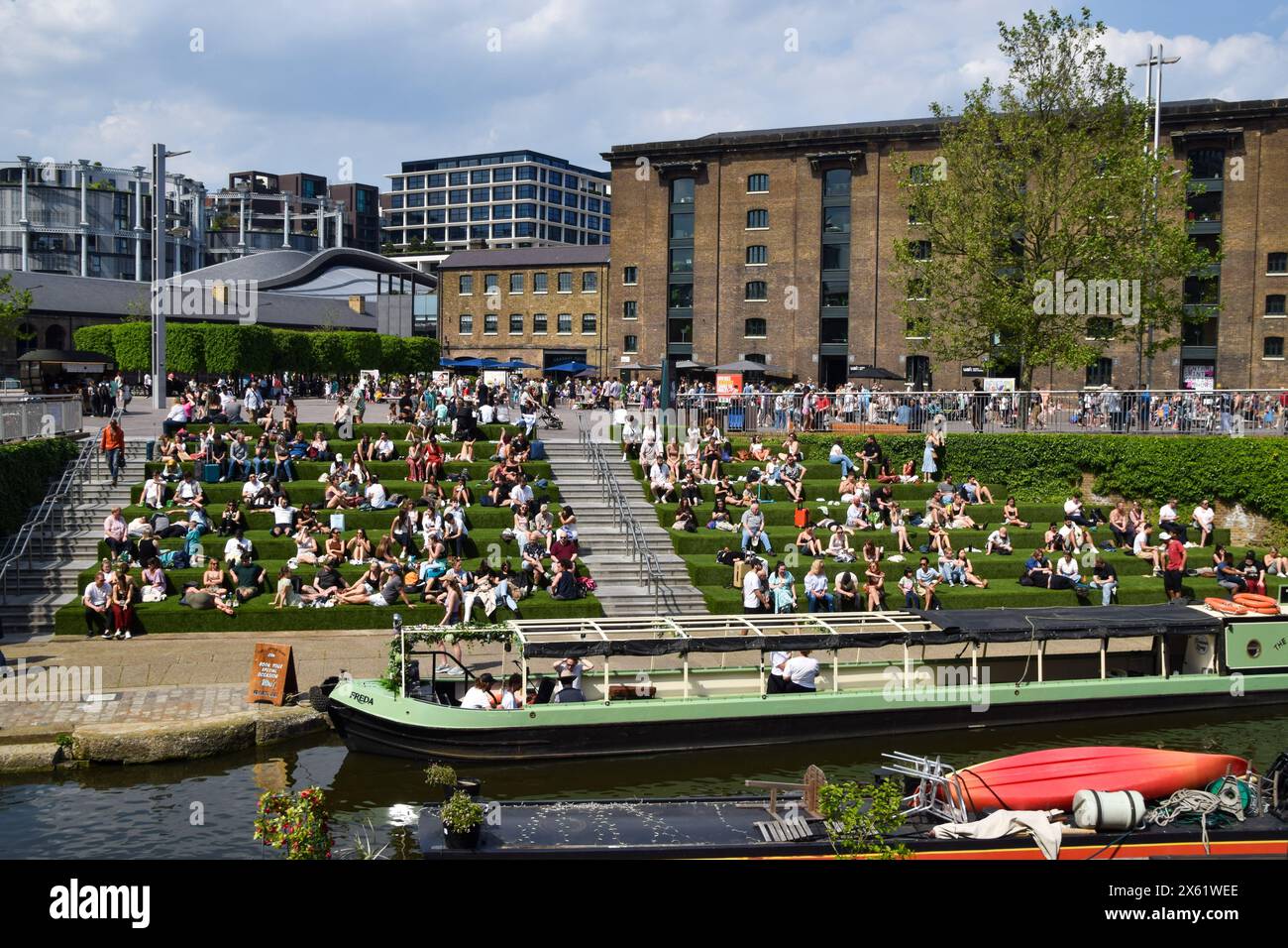 London, UK. 12th May 2024. People enjoy the sunshine on the artificial grass on the steps in Granary Square next to Regent's Canal in King's Cross, as the UK records the hottest day of the year so far. Credit: Vuk Valcic/Alamy Live News Stock Photo