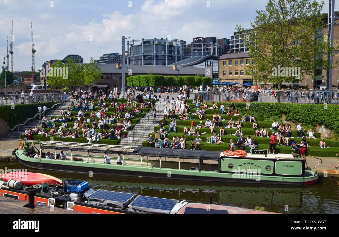 London, UK. 12th May 2024. People enjoy the sunshine on the artificial grass on the steps in Granary Square next to Regent's Canal in King's Cross, as the UK records the hottest day of the year so far. Credit: Vuk Valcic/Alamy Live News Stock Photo