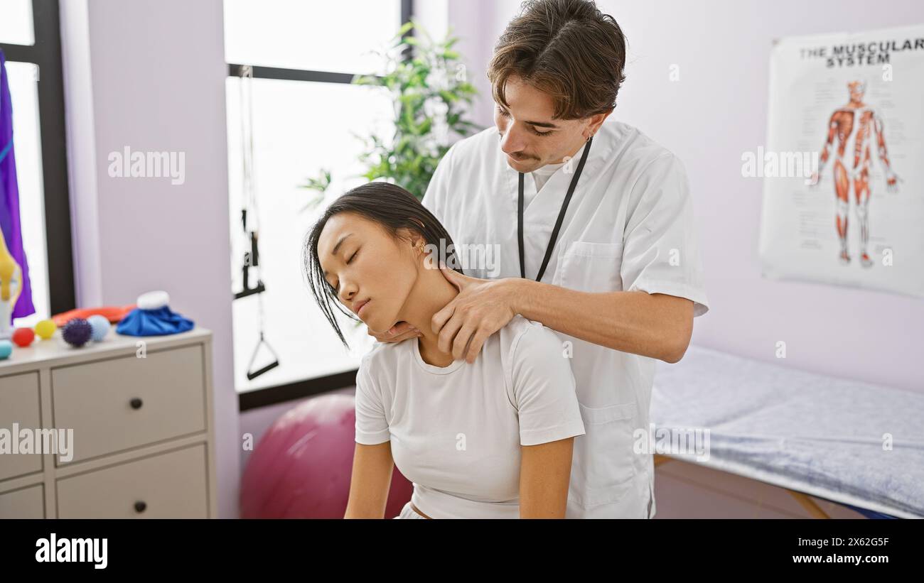 A male therapist performs a neck adjustment on a female patient in a ...