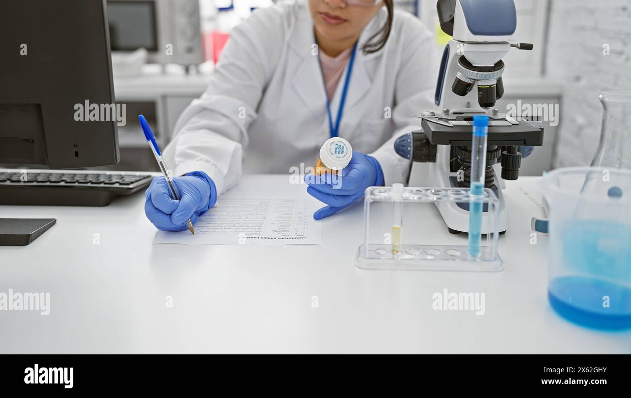 Taking Lab Notes Hispanic woman scientist in lab coat taking notes while examining ...
