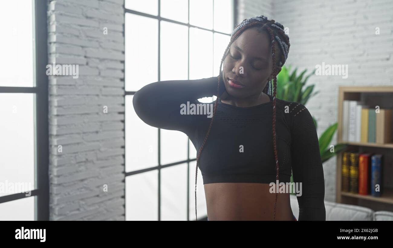 African american woman with braids experiencing neck pain indoors at ...